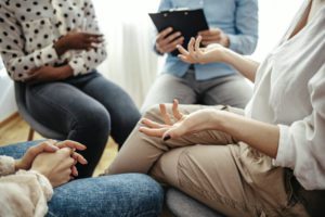 Unrecognizable vulnerable woman participates in group therapy session.